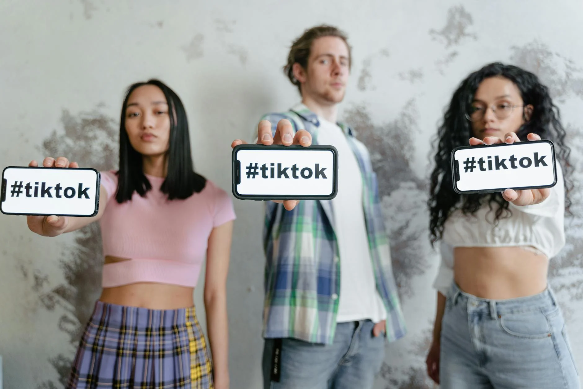 three people holding phones