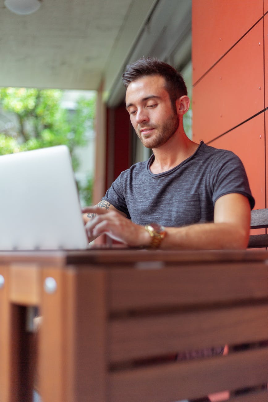 Professional working on a laptop and phone at a desk