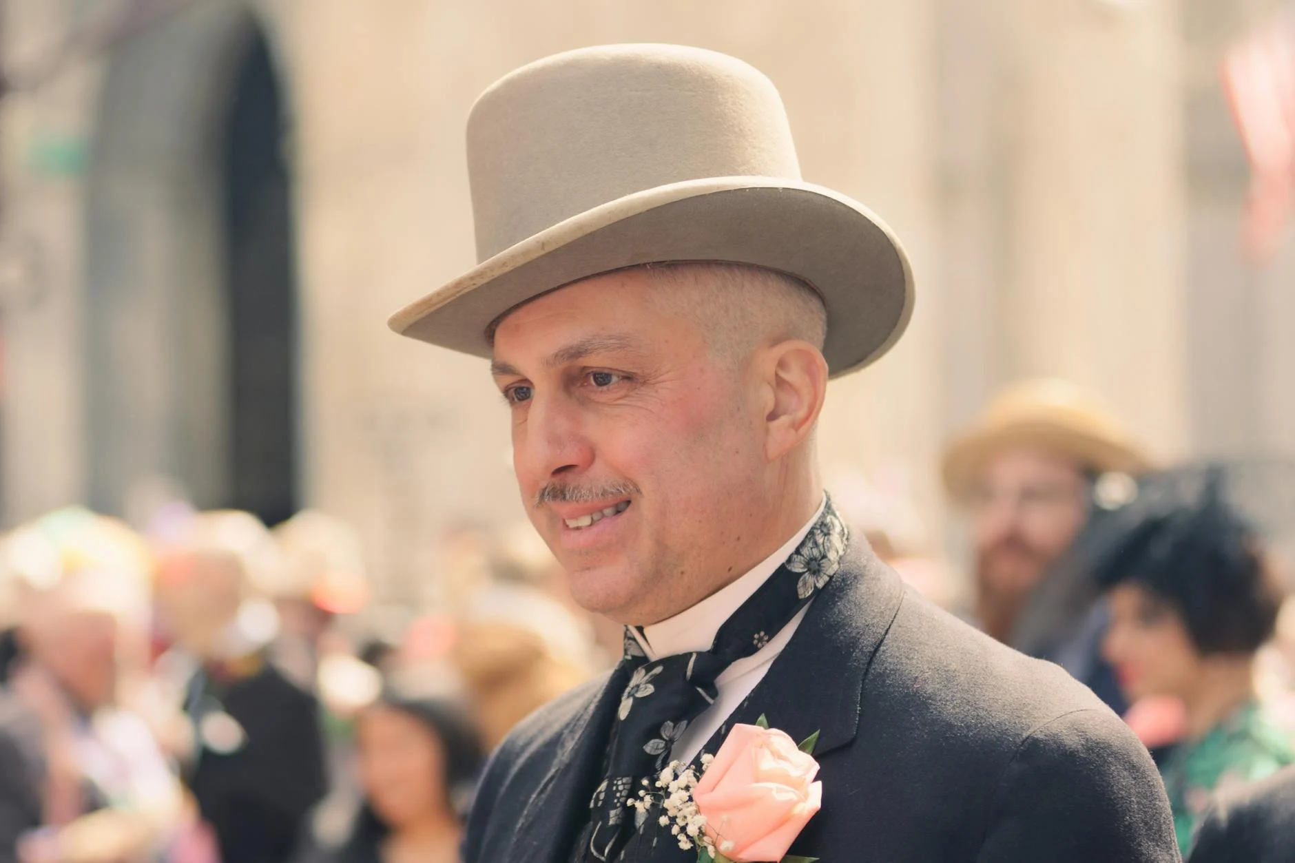 a man in a suit and a beige hat